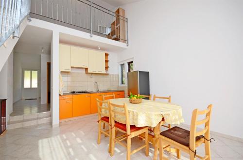 eine Küche und ein Esszimmer mit einem Tisch und Stühlen in der Unterkunft Apartments Edi in Gdinj