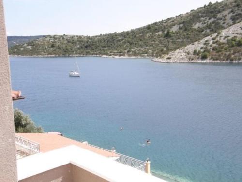 Blick auf einen großen Wasserkörper mit einem Segelboot in der Unterkunft Apartments Ljubica in Vinišće