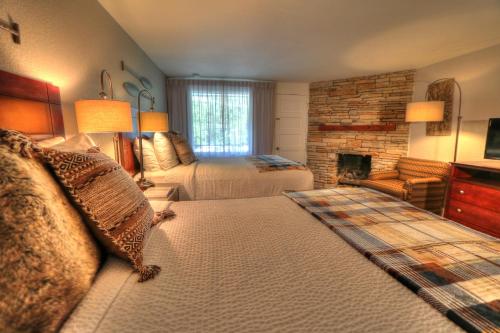 a bedroom with two beds and a fireplace at River Edge Inn in Gatlinburg
