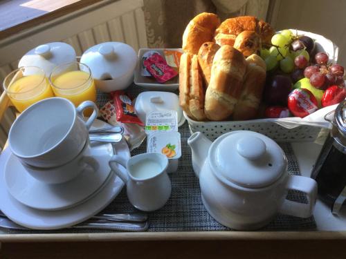 a tray with cups and a tray of breakfast foods at Inverlochy Villas (Adults Only) in Fort William