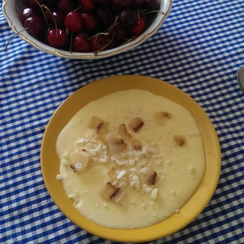 a yellow plate with food on a table with a bowl of grapes at Homestay Khomenko in Perechin
