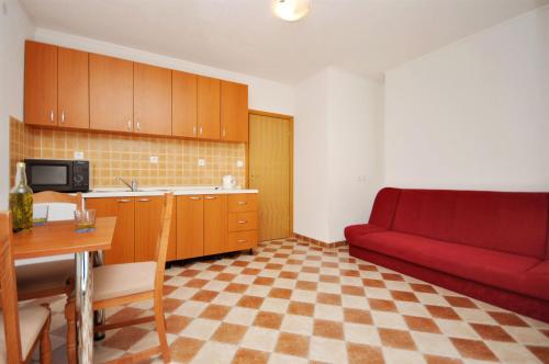 a living room with a red couch and a table at Apartments Blazenka in Trogir