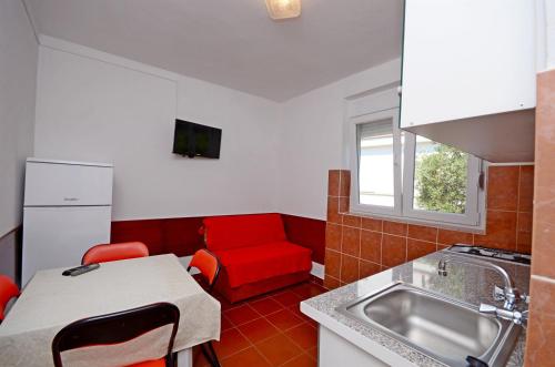 a kitchen with a red couch and a red chair at Apartments Josko in Gradac