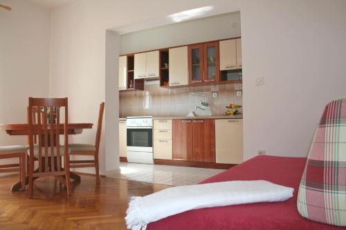 a kitchen with a couch and a table in a room at Apartment Anton in Slatine