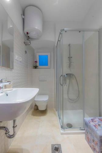a bathroom with a shower and a sink and a toilet at Season4All Apartments in Mali Lošinj