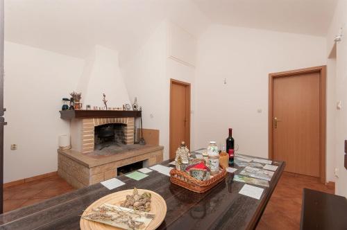 a living room with a table and a fireplace at House Vela Lozna in Postira