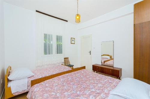 a bedroom with two beds and a mirror at House Rose in Živogošće
