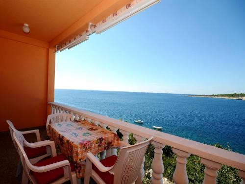 a balcony with a table and chairs and the ocean at Apartments Marijo in Sevid