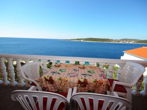 Ein Tisch und Stühle auf einem Balkon mit Meerblick in der Unterkunft Apartments Marijo in Sevid