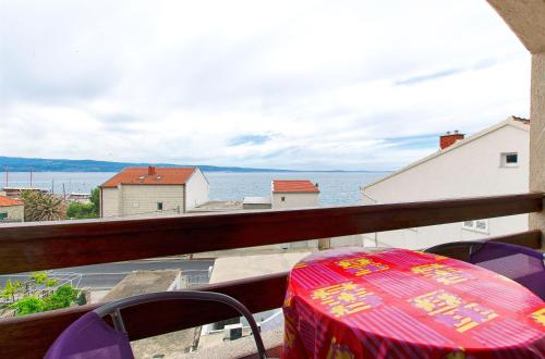a table on a balcony with a view of the water at Apartments Nevenka in Sumpetar