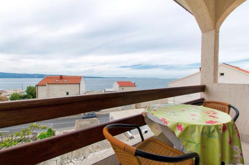 a table and chairs on a balcony with a view of the ocean at Apartments Nevenka in Sumpetar
