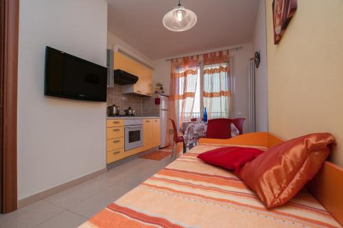 a bedroom with a bed and a kitchen with a television at Residence Blu Marine in Rimini