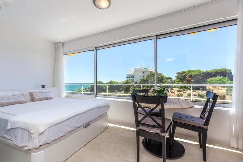 a bedroom with a bed and a desk and a large window at Marbellamar apartamento in Mijas