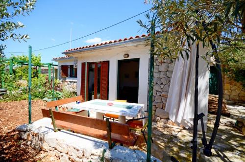 a table and a bench in front of a house at House Mislav II in Velike Kuknjare