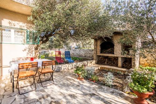 a patio with a table and chairs and a fireplace at Apartment Srecko in Vinišće