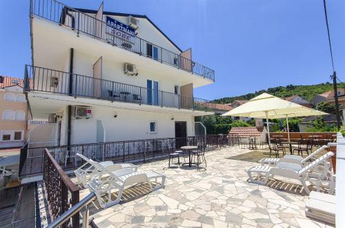 a patio with chairs and tables and a building at Apartments and Rooms Iva in Trogir