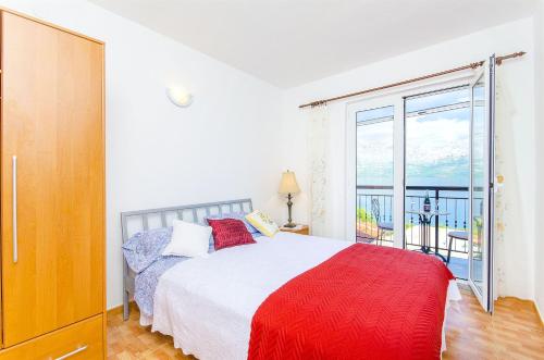 1 dormitorio con cama y ventana grande en Apartments Rose, en Sućuraj