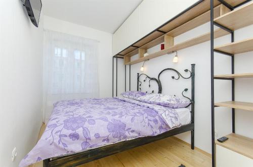 a bedroom with a bed with purple comforter at Apartment Roberto in Split