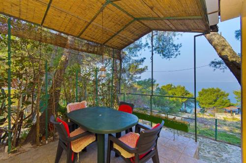 a table and chairs on a patio with a view of the ocean at House Fisherman in Postira