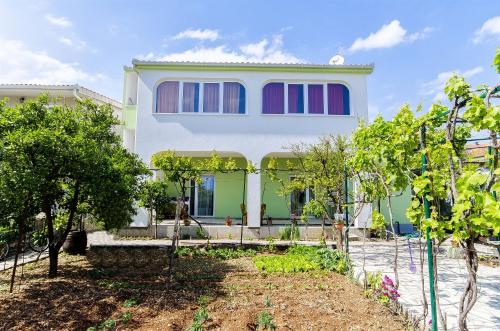 ein Haus mit Bäumen davor in der Unterkunft Apartments Branka in Trogir