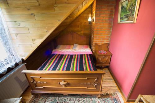a wooden staircase with a bed in a room at OBERŻA in Borsuki