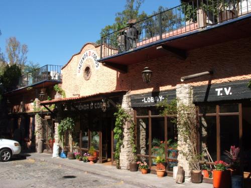 a building on a street with flowers and plants at Hotel Hacienda de Cobos in Guanajuato