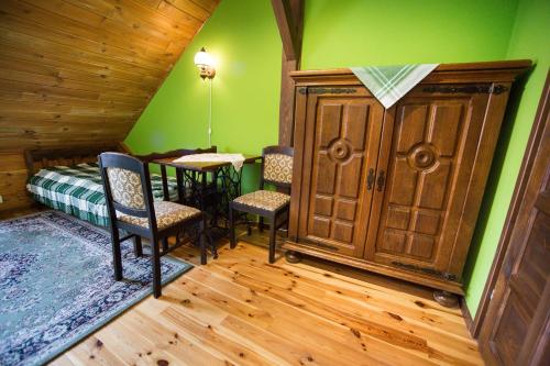 a room with green walls and a table and chairs at OBERŻA in Borsuki