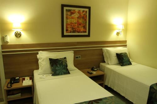 een hotelkamer met 2 bedden en 2 lampen bij Palace Hotel Campos dos Goytacazes in Campos dos Goytacazes