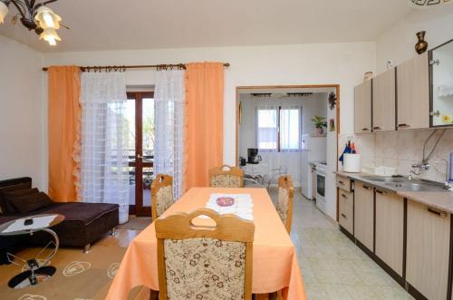 una cucina e una sala da pranzo con tavolo in una stanza di Apartments Zvonimir a Senj