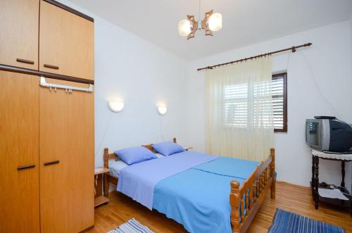 una camera con letto blu e TV di Apartments Zvonimir a Senj