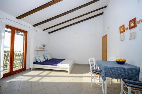 a bedroom with a bed and a table and a window at Apartments Nina in Stinica