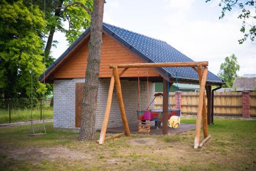 a playground with a swing and a house at OBERŻA in Borsuki