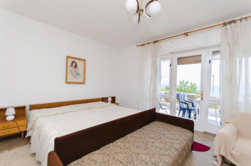 een slaapkamer met een bed, een bank en een raam bij Apartments Jadrana in Novi Vinodolski