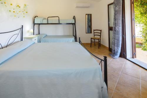 a bedroom with a bed and a balcony at Agriturismo Lu Nodu in Greuli 