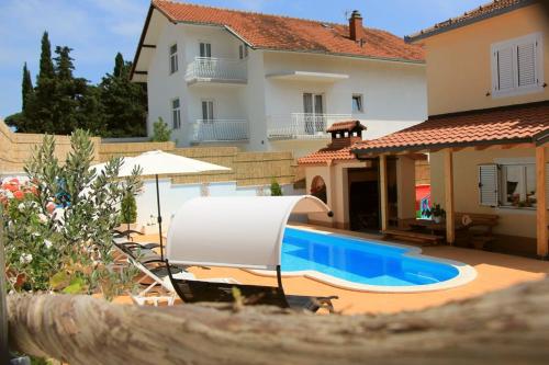 eine Villa mit einem Pool vor einem Haus in der Unterkunft Apartment Darija with private pool in Kaštela