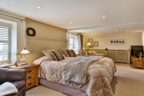 a bedroom with a large bed and a television at The Coach House Brecon in Brecon