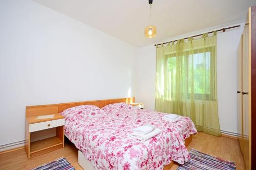 - une chambre avec un lit, un bureau et une fenêtre dans l'établissement Apartments Ante, à Njivice