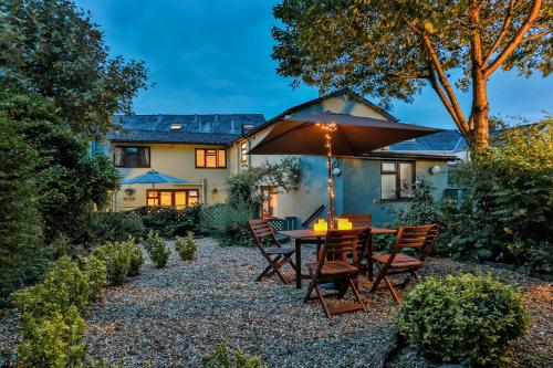 a patio with a table and chairs and an umbrella at The Coach House in Brecon