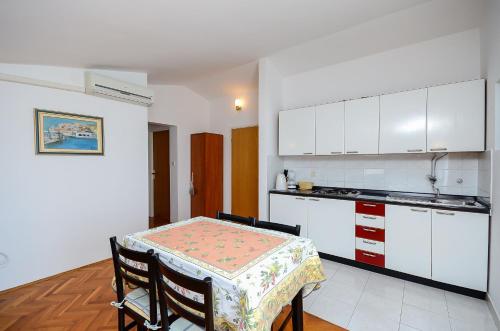 a kitchen with a table and a kitchen with white cabinets at Apartments Dragica in Štinjan