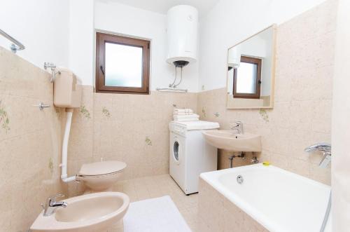 a bathroom with a sink and a toilet and a tub and a sink at Apartment Marija in Poreč