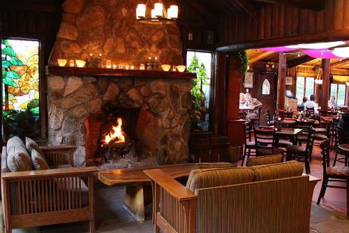 a fireplace in a restaurant with chairs and a table at Big Sur River Inn in Big Sur