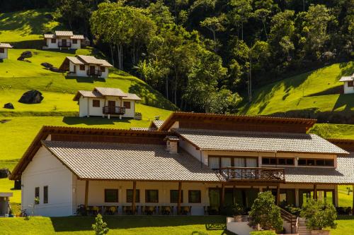 a house in the middle of a green hill at Pousada Bela Aurora in Venda Nova do Imigrante