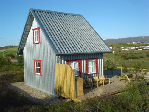 a small house with a porch and a deck at Vinland Cottage in Egilsstaðir