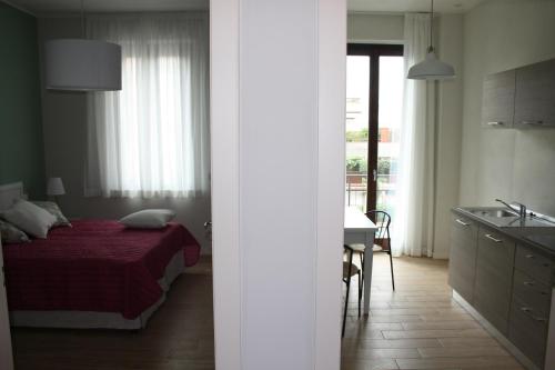 a bedroom with a bed and a kitchen with a sink at Appartamenti Emilio in Prato