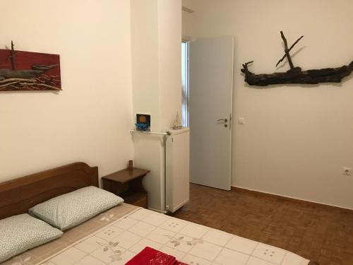 1 dormitorio con 1 cama, nevera y puerta en Art House In Athens, en Atenas
