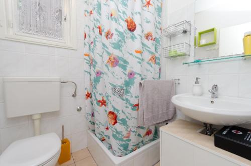 łazienka z umywalką, toaletą i zasłoną prysznicową w obiekcie House Mirella w mieście Mošćenička Draga