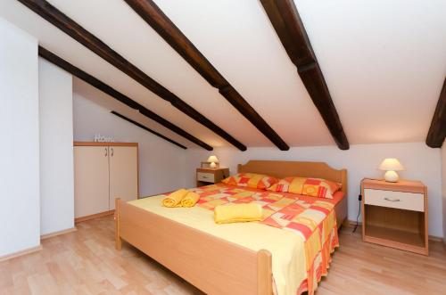 Apartment Mauro في بونات: غرفة نوم بسرير كبير ومخدات صفراء وبرتقالية