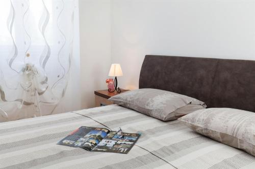 a bed with a pillow and a magazine on it at Villa Luna in Sutomišćica