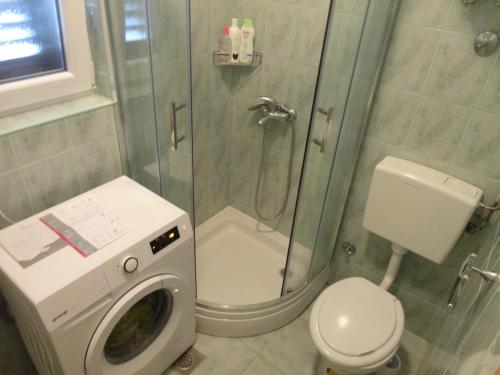 a bathroom with a shower with a washing machine at Apartment Ivana in Biograd na Moru