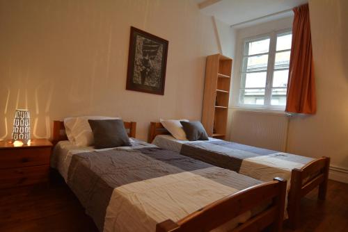 una camera con due letti e una finestra di Appartement Saint-Malo Intra Muros a Saint Malo